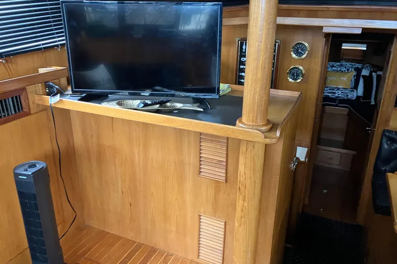 Slide: The Image of 1987 President 37 Sundeck interior with TV, wooden cabinetry, and nautical decor. - 22