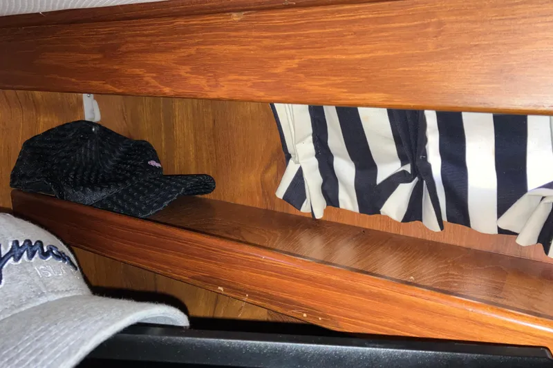 Slide: The Image of Wooden interior shelf with hats and striped curtain on a 1987 President 37 Sundeck yacht. - 53