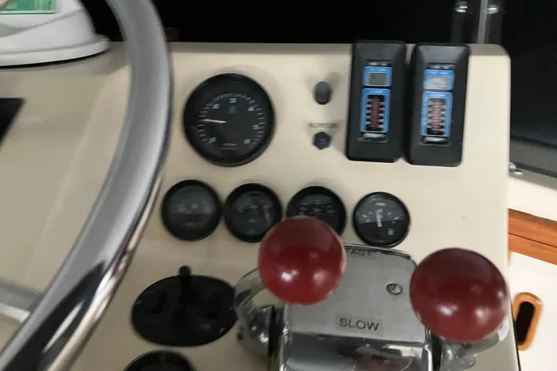 Slide: The Image of Control panel of a 1987 President 37 Sundeck boat with gauges and throttle levers. - 13