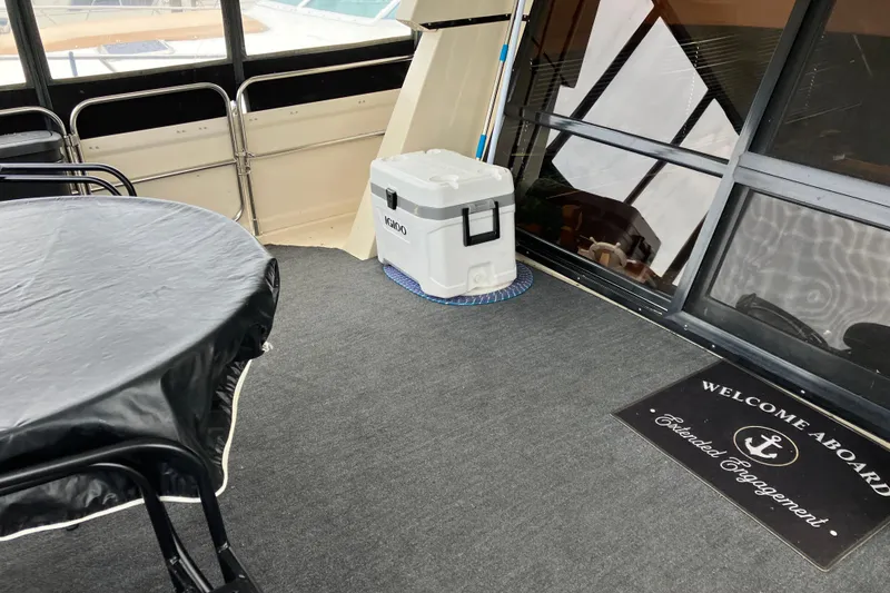 Slide: The Image of 1987 President 37 Sundeck interior with table, Igloo cooler, and welcome mat. - 4