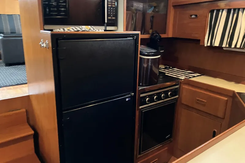 Slide: The Image of 1987 President 37 Sundeck yacht kitchen with fridge, stove, and microwave. - 33