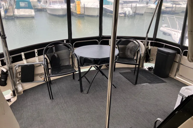 Slide: The Image of 1987 President 37 Sundeck yacht interior with chairs and table, overlooking marina. - 23