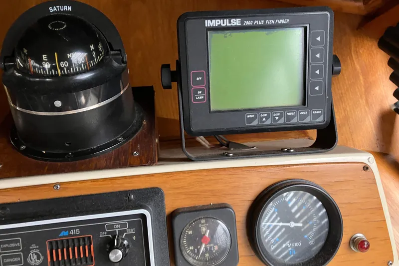 Slide: The Image of 1987 President 37 Sundeck boat dashboard with compass, fish finder, and gauges. - 26