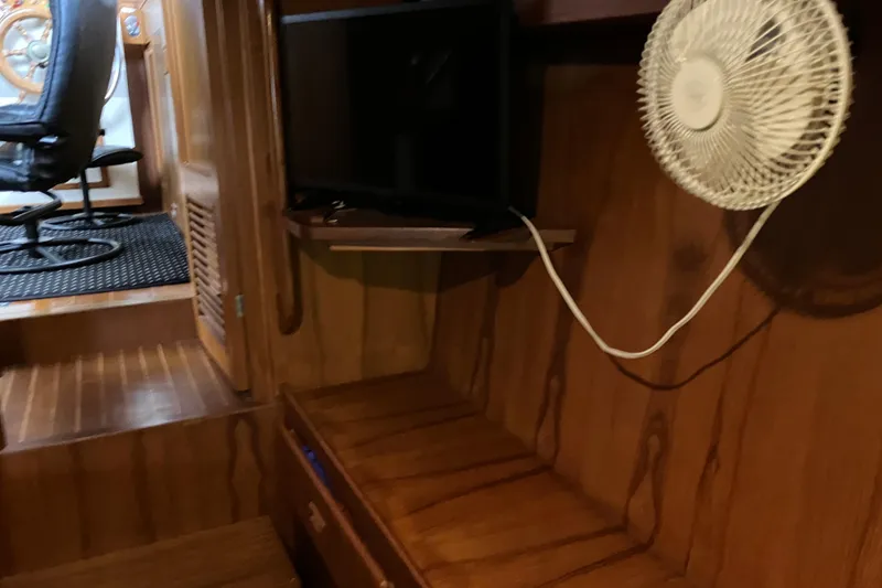 Slide: The Image of 1987 President 37 Sundeck interior with wooden paneling, fan, and seating area. - 56
