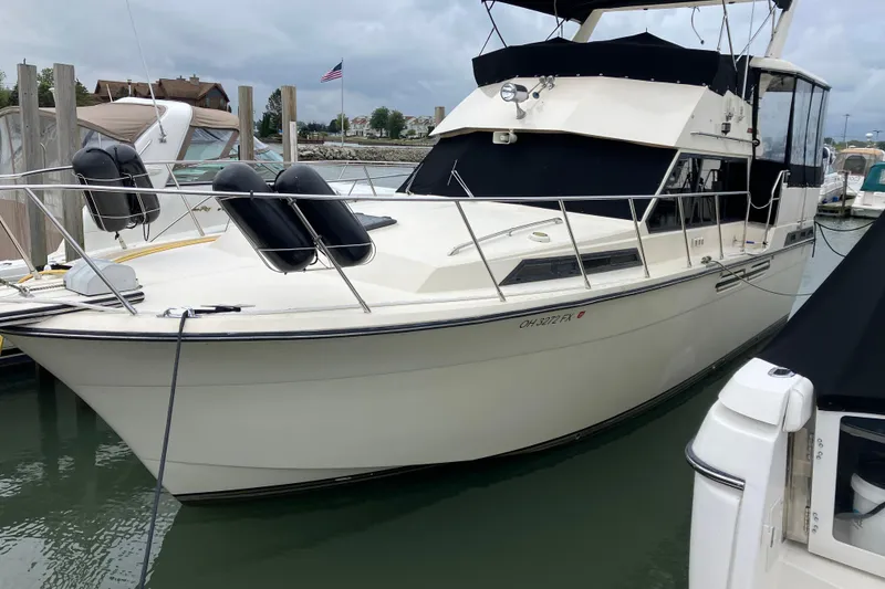 The Image of 1987 President 37 Sundeck yacht docked in marina, featuring sleek design and American flag. - 0