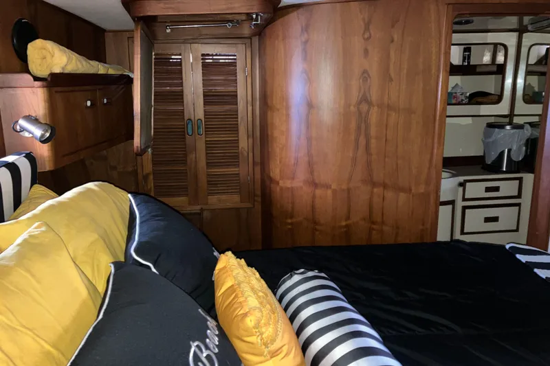 Slide: The Image of 1987 President 37 Sundeck interior with cozy bed, wooden cabinets, and nautical decor. - 46