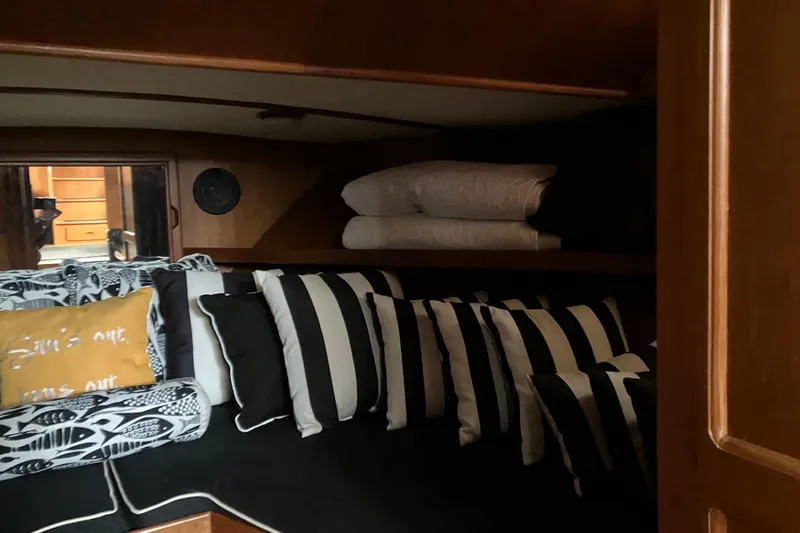 Slide: The Image of Cozy cabin interior of 1987 President 37 Sundeck with striped cushions and pillows. - 43