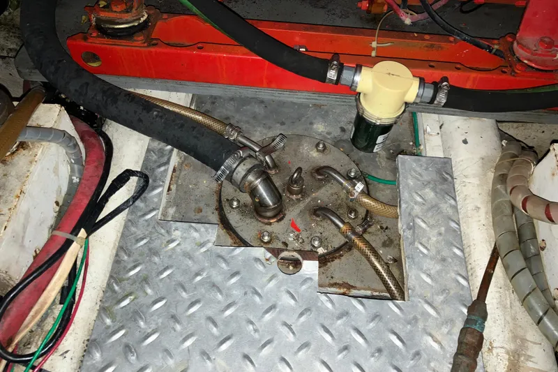 Slide: The Image of Engine compartment of a 1987 President 37 Sundeck boat with hoses and metal fittings. - 65