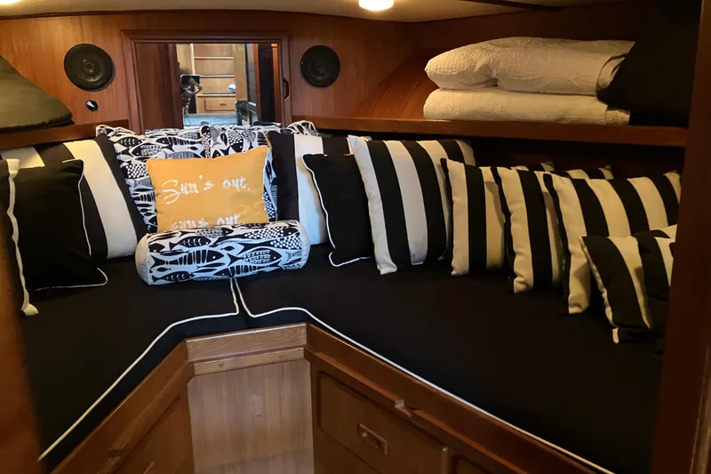 Slide: The Image of Cozy cabin interior of 1987 President 37 Sundeck with striped pillows and wood paneling. - 41
