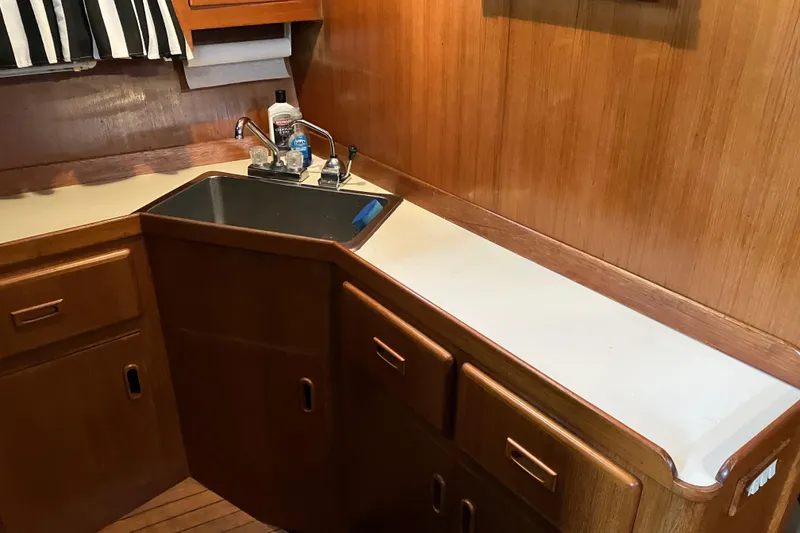 Slide: The Image of 1987 President 37 Sundeck yacht kitchen with wooden cabinets and sink. - 37