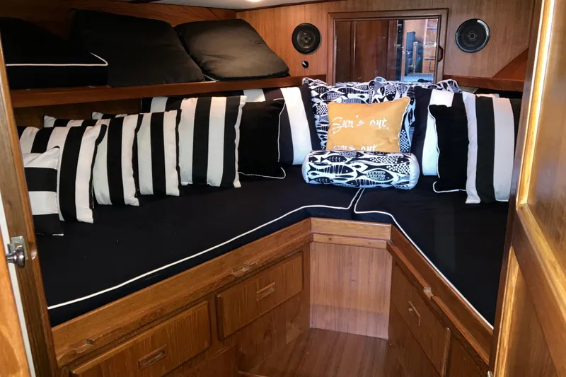 Slide: The Image of Cozy cabin interior of 1987 President 37 Sundeck with striped cushions and wooden finish. - 42