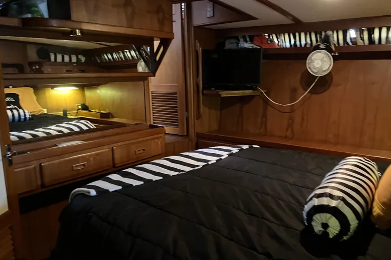 Slide: The Image of Cozy cabin interior of 1987 President 37 Sundeck with striped bedding and wooden furnishings. - 48