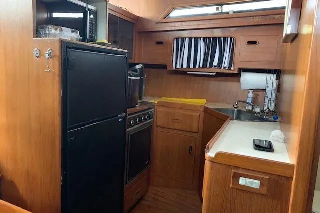 Slide: The Image of 1987 President 37 Sundeck yacht kitchen with wood cabinetry and appliances. - 32