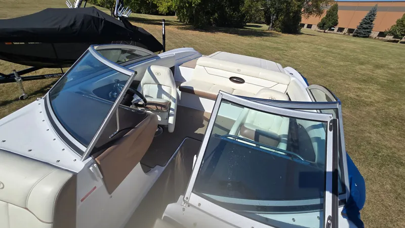 Slide: The Image of 2013 Cobalt 210 boat with open seating, parked on grass. - 10