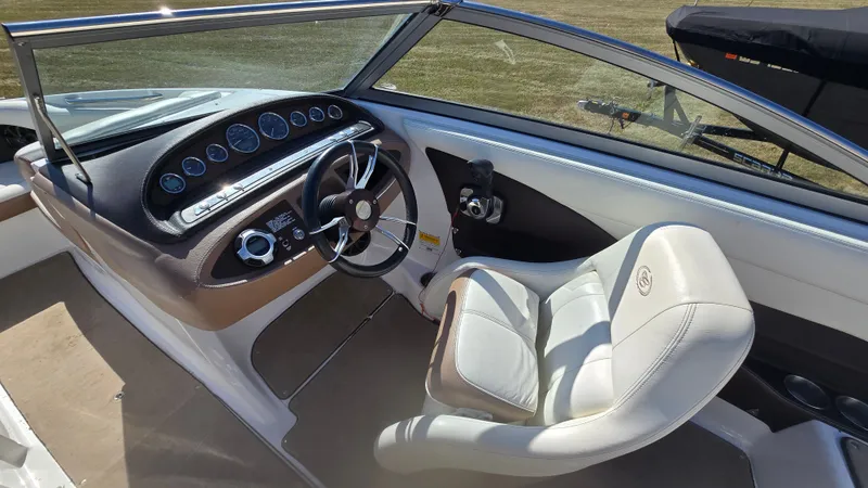 Slide: The Image of Interior of a 2013 Cobalt 210 boat featuring steering wheel and dashboard controls. - 11
