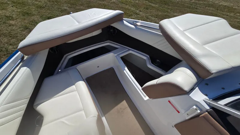 Slide: The Image of Interior of a 2013 Cobalt 210 boat with white and beige seating. - 18