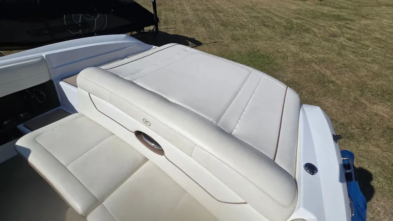 Slide: The Image of 2013 Cobalt 210 boat with white leather seating on grassy area. - 22