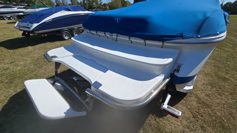 Slide: The Image of 2013 Cobalt 210 boat with blue cover and swim platform on grass. - 3