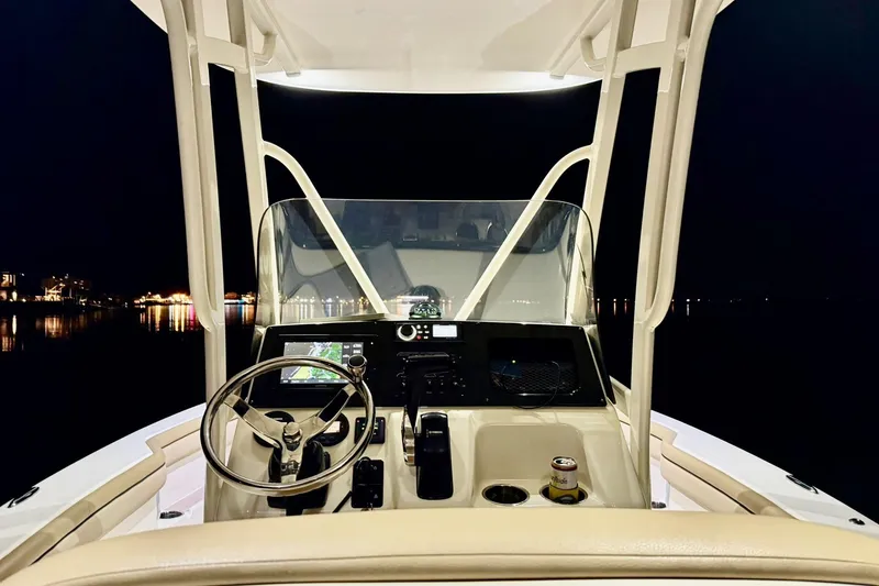 Slide: The Image of 2018 Scout 215 XSF boat dashboard at night, featuring steering wheel and controls. - 7