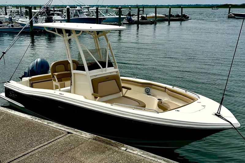 Slide: The Image of 2018 Scout 215 XSF boat docked at marina, featuring sleek design and spacious seating. - 9