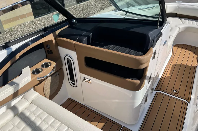 Slide: The Image of 2021 Cobalt R30 boat interior with tan and white seating, cup holders, and wood-style flooring. - 11