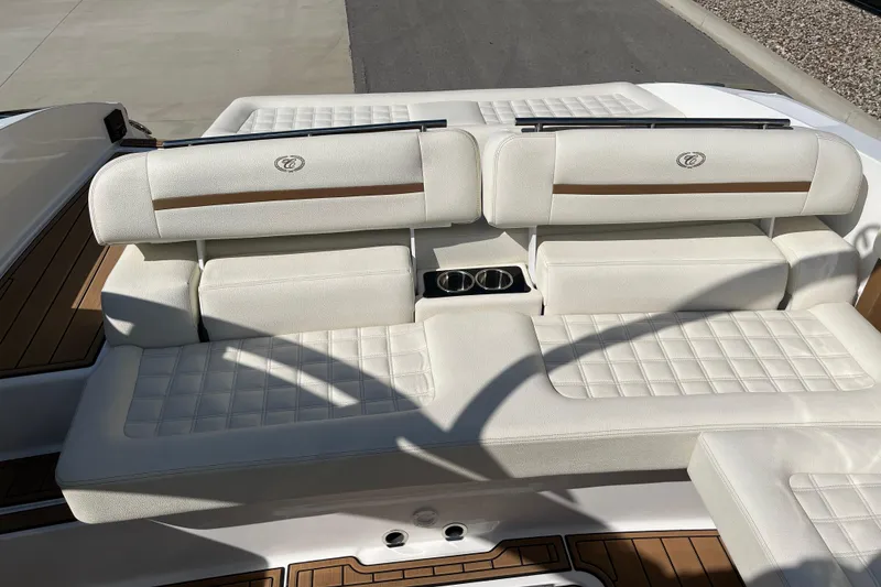 Slide: The Image of 2021 Cobalt R30 boat interior with white cushioned seating and wood accents. - 16