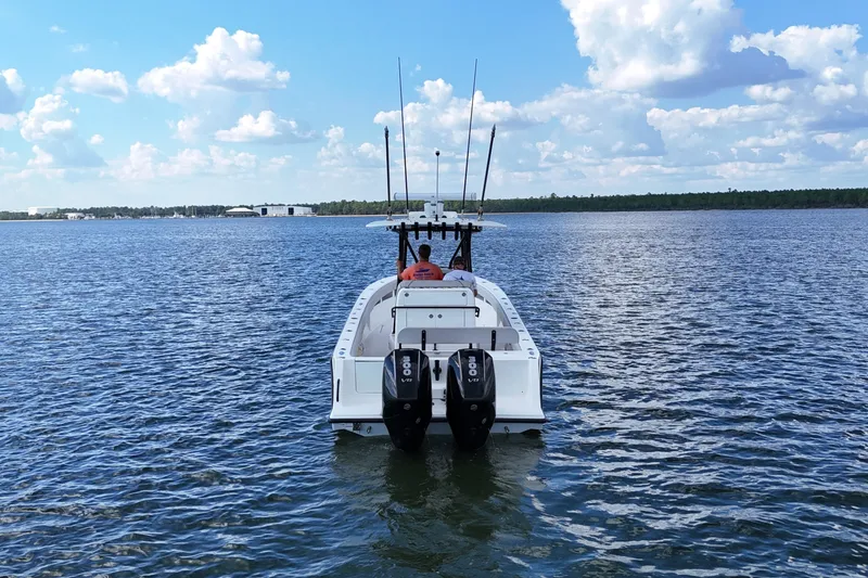 Slide: The Image of 2023 SeaVee 32 boat on open water with twin engines, clear sky. - 1