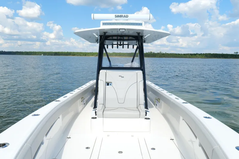 Slide: The Image of 2023 SeaVee 32 boat on calm water under a blue sky with clouds. - 32