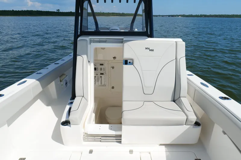 Slide: The Image of 2023 SeaVee 32 boat interior with seating and storage, on calm water. - 33
