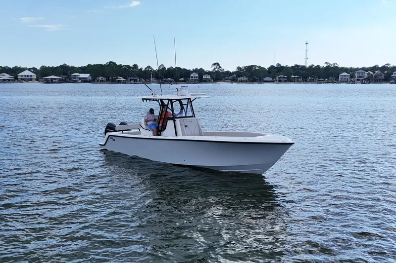 Slide: The Image of 2023 SeaVee 32 boat on calm water near shoreline houses. - 4