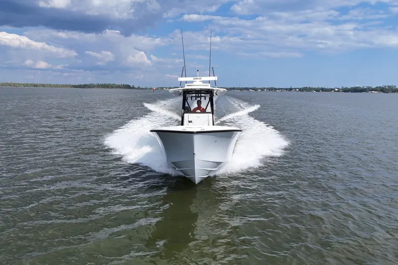 Slide: The Image of 2023 SeaVee 32 boat cruising on open water under a partly cloudy sky. - 46