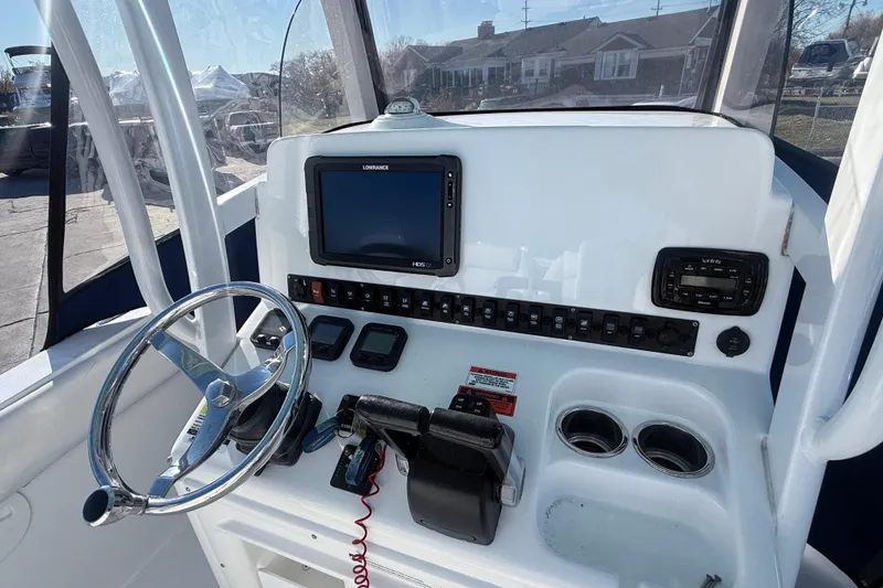 Slide: The Image of 2015 Sea Hunt Gamefish 25 dashboard with steering wheel, controls, and navigation display. - 12