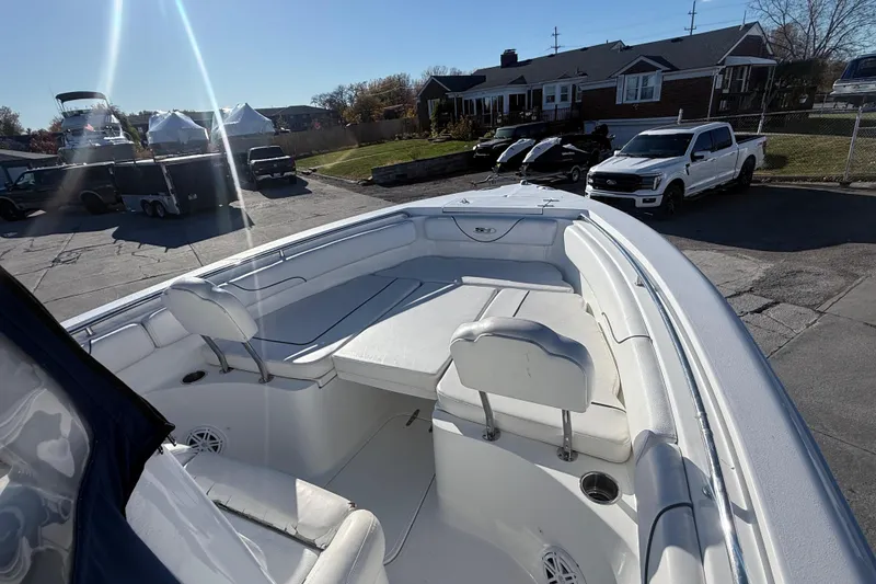 Slide: The Image of 2015 Sea Hunt Gamefish 25 boat with spacious seating, parked outdoors in a residential area. - 16