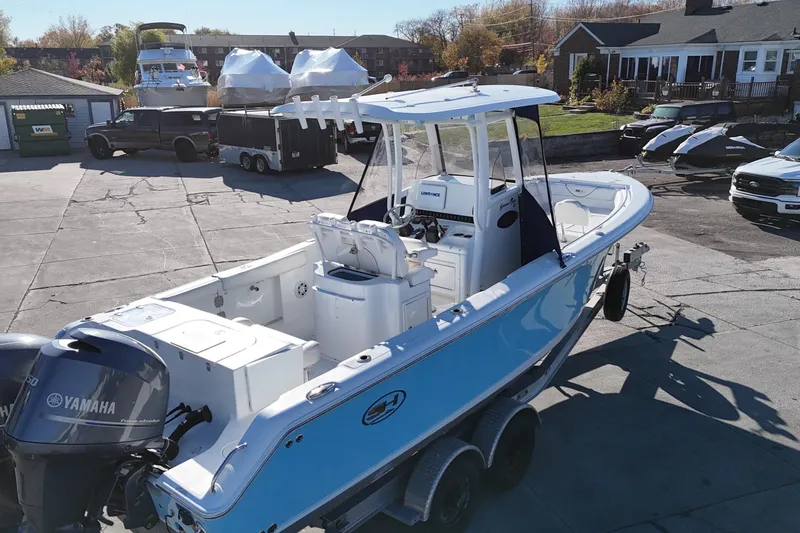 Slide: The Image of 2015 Sea Hunt Gamefish 25 boat with Yamaha engine on trailer in driveway. - 2