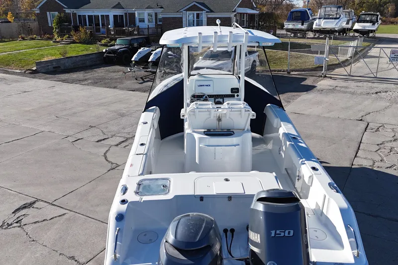 Slide: The Image of 2015 Sea Hunt Gamefish 25 boat with Yamaha 150 engine, parked near a house. - 5