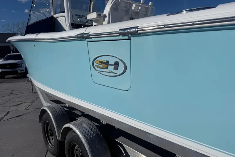 Slide: The Image of 2015 Sea Hunt Gamefish 25 boat on trailer, light blue hull, sunny day. - 6