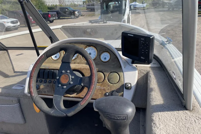 Slide: The Image of 2004 Starcraft C-Star 1800 OB boat interior with two gray seats and steering wheel. - 10