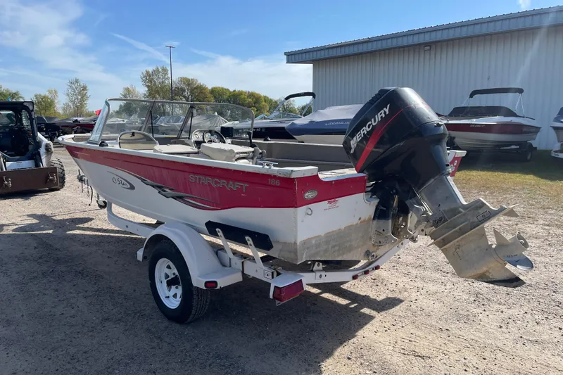 Slide: The Image of 2004 Starcraft C-Star 1800 OB with Mercury 90 outboard motor, parked among other boats. - 4