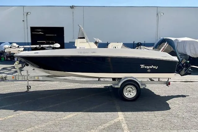 Slide: The Image of 2026 Bayliner Trophy T18 boat on trailer, parked outdoors. - 3