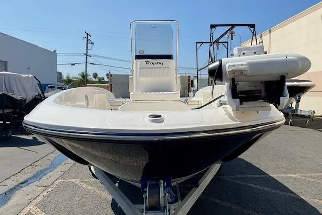Slide: The Image of 2026 Bayliner Trophy T18 boat on trailer, parked outdoors in a sunny setting. - 6