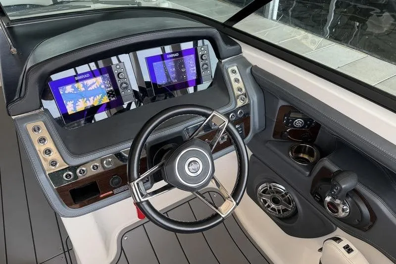 Slide: The Image of 2021 Chaparral 307 SSX boat dashboard with dual Simrad displays and steering wheel. - 13