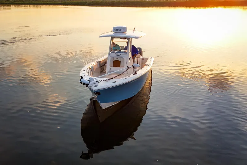 Slide: The Image of 2023 Cobia 262cc boat on calm water at sunset, featuring Garmin equipment. - 3