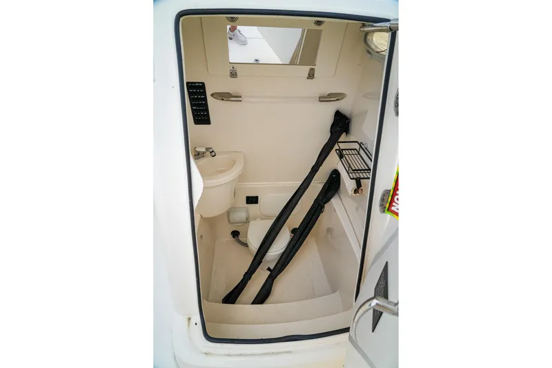 Slide: The Image of 2023 Cobia 262cc boat interior with compact bathroom and storage space. - 6