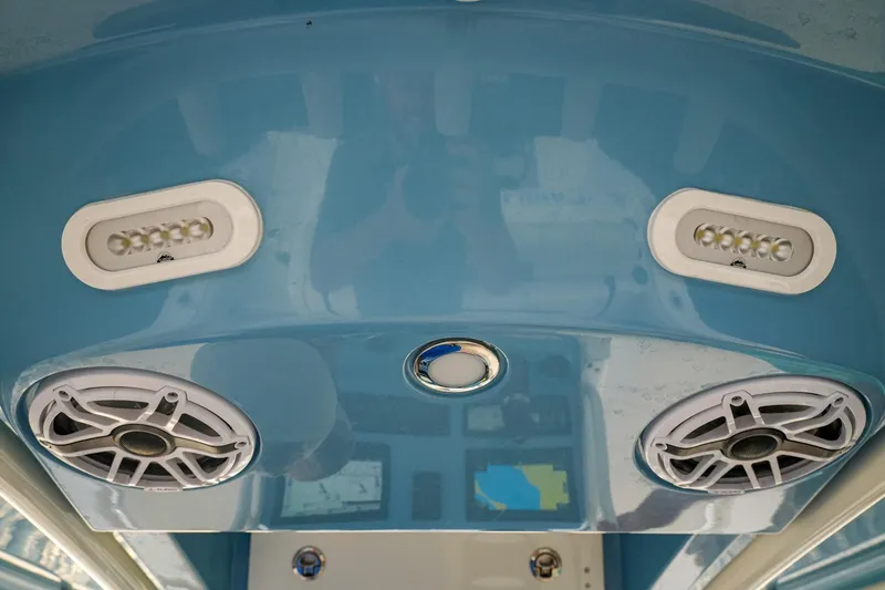 Slide: The Image of 2023 Cobia 262cc boat interior with speakers and LED lights on blue panel. - 8