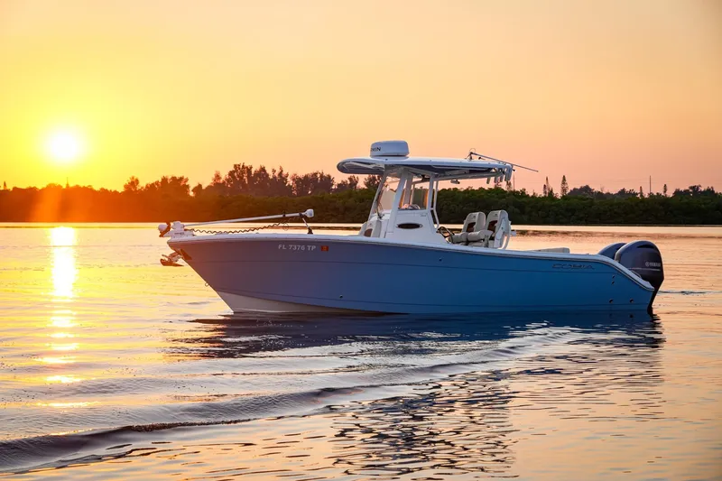 Slide: The Image of 2023 Cobia 262cc boat cruising at sunset on calm waters. - 9