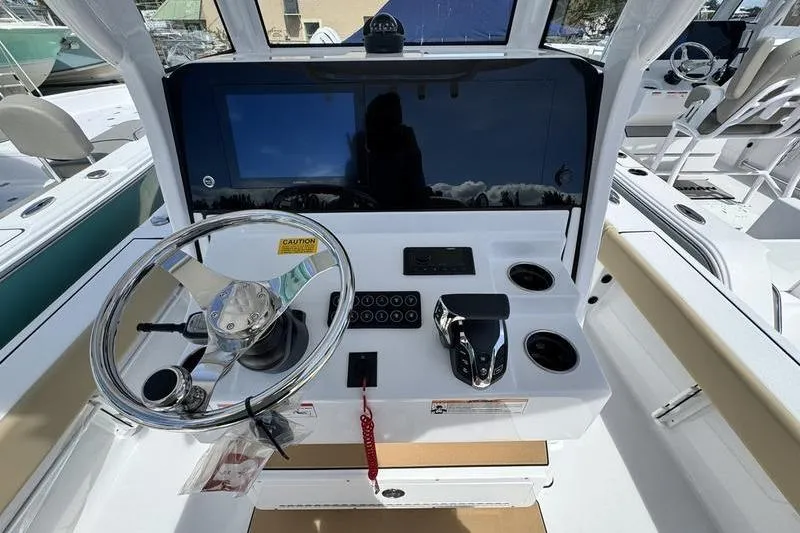 Slide: The Image of 2026 Sportsman Masters 247OE Bay Boat helm with steering wheel and control panel. - 12