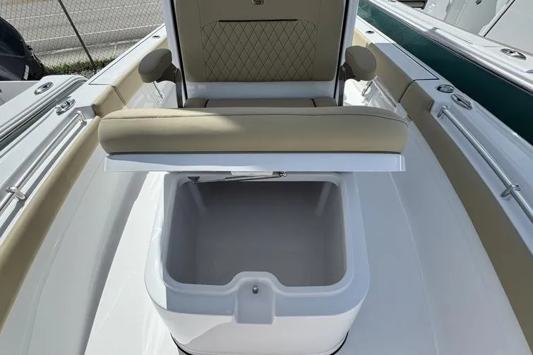 Slide: The Image of 2026 Sportsman Masters 247OE Bay Boat with open storage compartment and cushioned seating. - 14