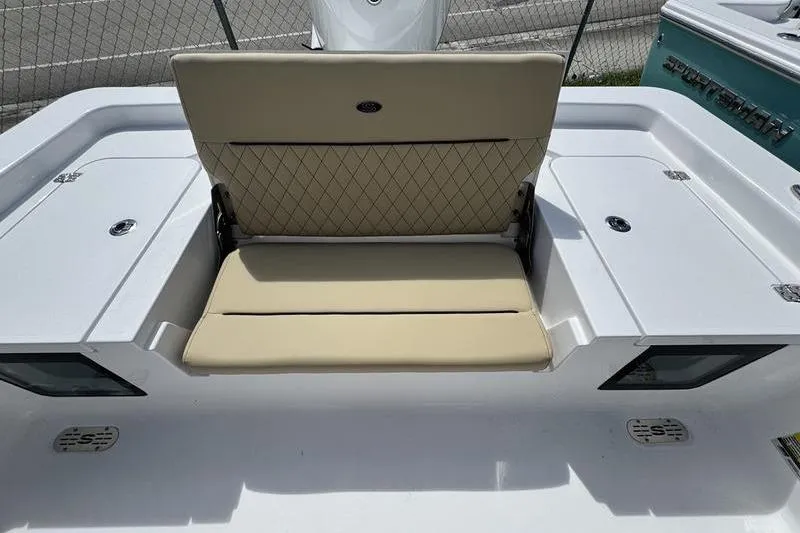 Slide: The Image of 2026 Sportsman Masters 247OE Bay Boat with beige cushioned seating and storage compartments. - 17