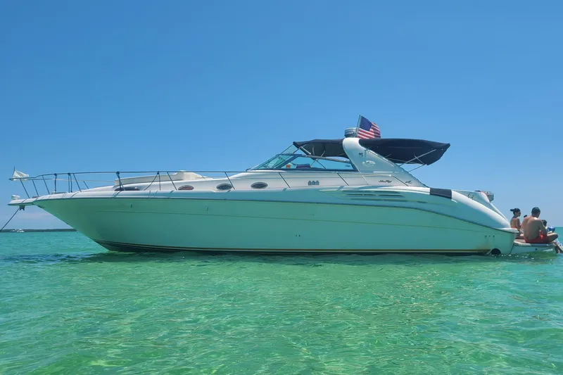 The Image of 1995 Sea Ray 450 Sundancer yacht on clear turquoise water under a bright blue sky. - 1