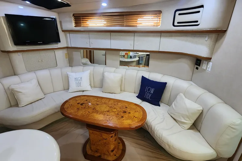 Slide: The Image of Interior of 1995 Sea Ray 450 Sundancer with white seating and wooden table. - 3
